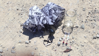 an umbrella, a glass jar and two thermometers in the sun